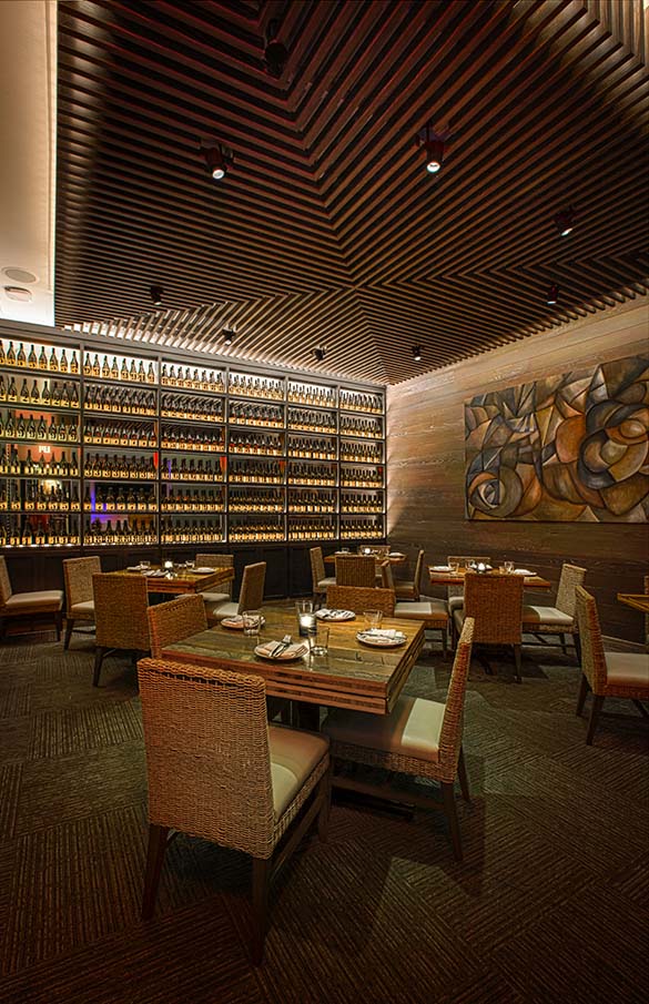 Private dining area with wine wall at Del Mar Mediterranean restaurant in Naples, Florida.