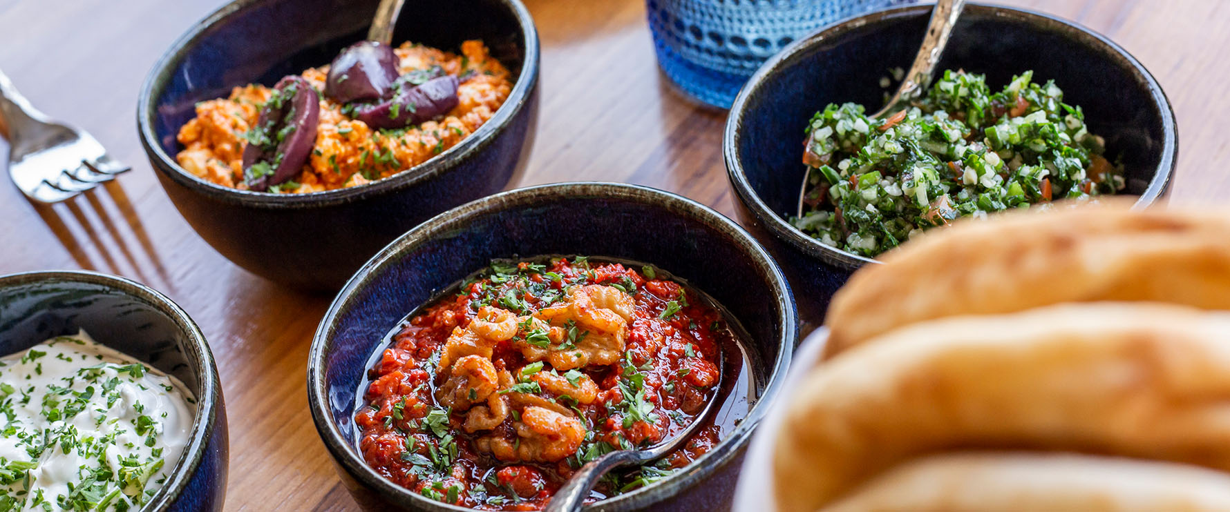 Close up of several dishes served at Del Mar on a table.