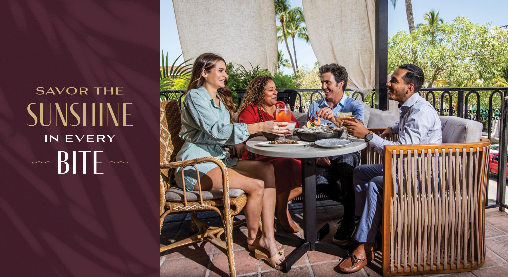 People enjoying cocktails and food on a sunny patio at Del Mar Mediterranean restaurant.