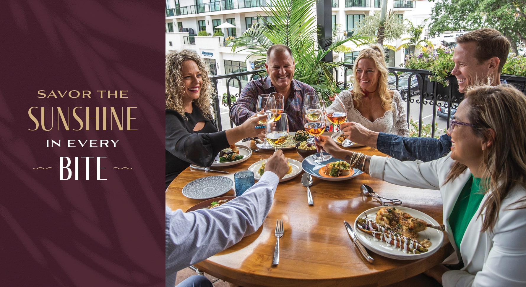 People enjoying cocktails and food on a sunny patio at Del Mar Mediterranean restaurant.